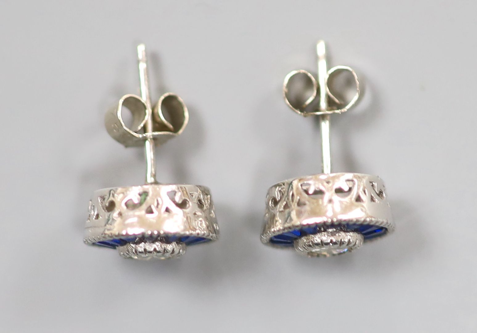 A pair of white metal (stamped China EJI) diamond and synthetic sapphire? set circular cluster earstuds, 10mm, gross 2.4 grams.